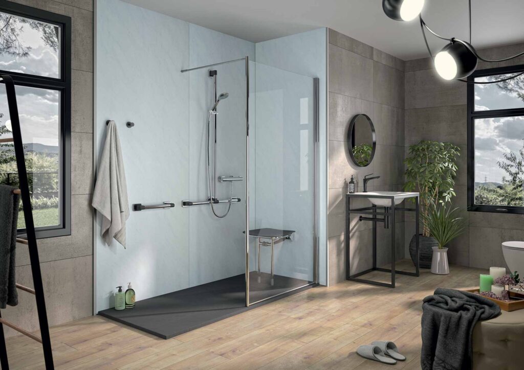 Salle de bain moderne avec douche à l'italienne sécurisée (siège, barres d'appui), panneaux clairs, sol bois clair. Lavabo design, grand miroir.